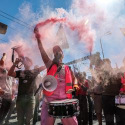 Un manifestante sostiene una bomba de humo mientras toca el tambor con otras personas durante una manifestación contra el polémico proyecto de ley de revisión judicial del gobierno israelí en Tel Aviv. | Foto:JACK GUEZ / AFP