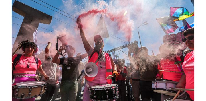 Un manifestante sostiene una bomba de humo mientras toca el tambor con otras personas durante una manifestación contra el polémico proyecto de ley de revisión judicial del gobierno israelí en Tel Aviv.