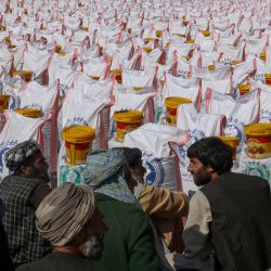 Hombres afganos esperan para recibir ayuda alimentaria distribuida por una fundación benéfica antes del mes sagrado de ayuno musulmán del Ramadán en el distrito de Injil de la provincia de Herat. | Foto:Mohsen Karimi / AFP