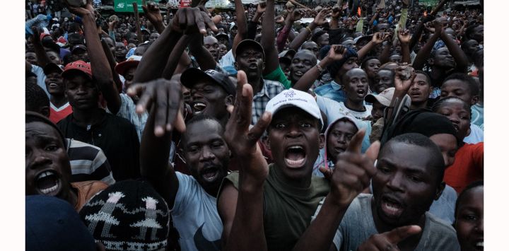 Simpatizantes reaccionan mientras Raila Odinga, líder de la coalición opositora keniana "Azimio la Umoja", habla durante un mitin convocado por Odinga, que afirma que las últimas elecciones presidenciales fueron robadas y culpa al gobierno del aumento del coste de la vida, en la barriada de Mathare, en Nairobi