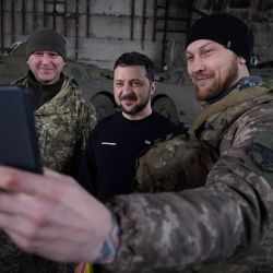 Esta fotografía tomada y difundida por el servicio de prensa de la Presidencia ucraniana muestra al presidente Volodymyr Zelensky haciéndose un selfie con militares tras reunirse con ellos en un almacén y entregarles condecoraciones, cerca de Bakhmut. | Foto:Handout / UKRAINIAN PRESIDENTIAL PRESS SERVICE / AFP