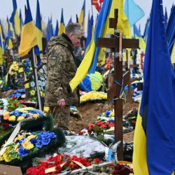 Un militar ucraniano visita el Callejón de los Héroes en un cementerio en Kharkiv, en medio de la invasión rusa de Ucrania. | Foto:SERGEY BOBOK / AFP