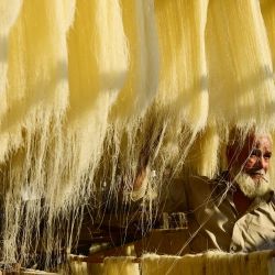 Un trabajador seca fideos, que se utilizan para elaborar platos dulces tradicionales consumidos popularmente durante el mes sagrado del Ramadán, en una fábrica de Allahabad, India. | Foto:SANJAY KANOJIA / AFP