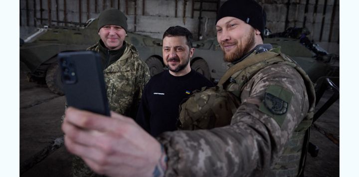 Esta fotografía tomada y difundida por el servicio de prensa de la Presidencia ucraniana muestra al presidente Volodymyr Zelensky haciéndose un selfie con militares tras reunirse con ellos en un almacén y entregarles condecoraciones, cerca de Bakhmut.