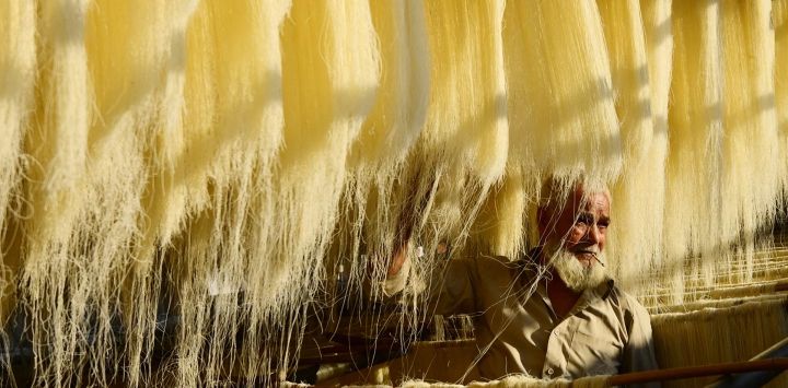 Un trabajador seca fideos, que se utilizan para elaborar platos dulces tradicionales consumidos popularmente durante el mes sagrado del Ramadán, en una fábrica de Allahabad, India.