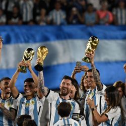Argentina's players celebrate with their families while holding up replicas of the World Cup trophy during a ceremony for the world champions following the friendly football match between Argentina and Panama at the Monumental stadium in Buenos Aires on March 23, 2023. 