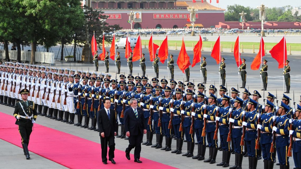 In this file photo taken on May 18, 2009, Brazil's visiting then-president Luiz Inácio Lula da Silva walks beside his Chinese counterpart Hu Jintao (centre) as they review an honour guard at a welcoming ceremony at the Great Hall of the People in Beijing. 