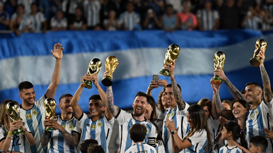 Argentina's players celebrate with their families while holding up replicas of the World Cup trophy during a ceremony for the world champions following the friendly football match between Argentina and Panama at the Monumental stadium in Buenos Aires on March 23, 2023. 