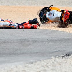 El piloto español de Honda Marc Marquez cae tras chocar con el piloto portugués de Aprilia Miguel Oliveira durante la carrera de MotoGP del Gran Premio de Portugal en el Circuito Internacional del Algarve en Portimao. | Foto:PATRICIA DE MELO MOREIRA / AFP
