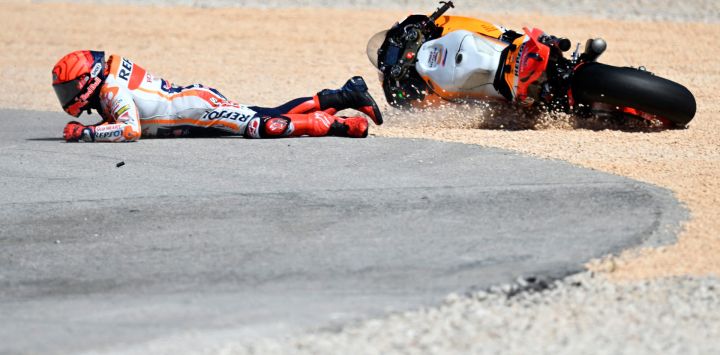 El piloto español de Honda Marc Marquez cae tras chocar con el piloto portugués de Aprilia Miguel Oliveira durante la carrera de MotoGP del Gran Premio de Portugal en el Circuito Internacional del Algarve en Portimao.