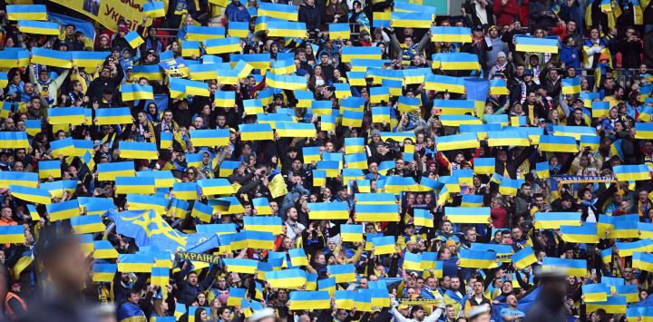 Seguidores de Ucrania sostienen banderas durante los himnos antes del partido de fútbol de clasificación del grupo C de la Eurocopa 2024 de la UEFA entre Inglaterra y Ucrania en el estadio de Wembley en Londres.