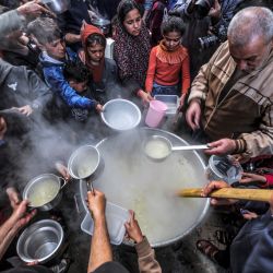 El palestino Walid al-Hattab reparte sopa de una olla grande a jóvenes empobrecidos para romper su ayuno en el segundo día del mes sagrado musulmán del Ramadán en la ciudad de Gaza. | Foto:MOHAMMED ABED / AFP