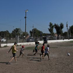 Children play football at the Los Pumitas neighbourhood in Rosario, Santa Fe Province, Argentina, taken on March 15, 2023. 