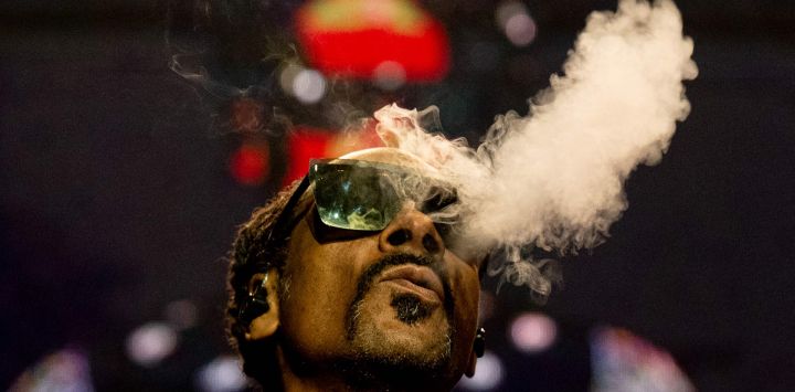 El rapero estadounidense Calvin Cordozar Broadus Jr alias Snoop Dogg echa humo mientras actúa en el escenario del Accor Arena de Bercy, en París.