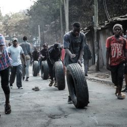 Manifestantes hacen rodar neumáticos hacia una barricada en Kibera, Nairobi, durante una protesta convocada por la coalición opositora "Azimio la Umoja". | Foto:YASUYOSHI CHIBA / AFP