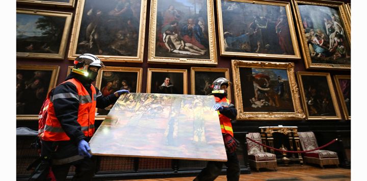 Los bomberos retiran una estampa mientras pasan junto a auténticas obras de arte durante un ejercicio en vivo para extinguir un incendio, salvar y retirar obras de arte y objetos históricos del Chateau de Chantilly, en Chantilly, al norte de París.