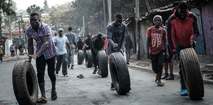 Manifestantes hacen rodar neumáticos hacia una barricada en Kibera, Nairobi, durante una protesta convocada por la coalición opositora "Azimio la Umoja".