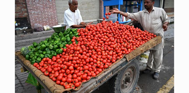 Un vendedor vende verduras en un carro tirado por caballos en una calle de Amritsar, India.