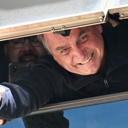 El expresidente brasileño Jair Bolsonaro saluda a sus partidarios desde una ventana en la sede del Partido Liberal en Brasilia. | Foto:EVARISTO SA / AFP