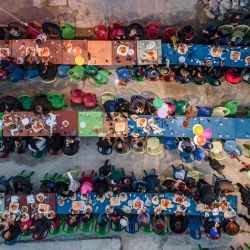 Esta vista aérea muestra a la población local afectada por el terremoto del 6 de febrero asistiendo a una cena masiva de ruptura del ayuno "Iftar" en la ciudad de Atareb, en el campo occidental de la provincia de Alepo controlado por los rebeldes, al final del día de ayuno durante el mes sagrado musulmán del Ramadán. | Foto:AAREF WATAD / AFP