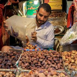 En esta imagen un comerciante de dátiles prepara un pedido para un cliente en un puesto de un mercado de la ciudad vieja de Sanaa durante el mes sagrado musulmán de ayuno del Ramadán. | Foto:MOHAMMED HUWAIS / AFP