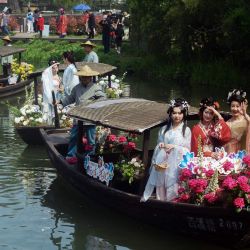 Esta foto muestra a artistas vestidos con el traje tradicional Hanfu posando como diosas de las flores mientras montan en barcos durante un evento turístico en Hangzhou, en la provincia oriental china de Zhejiang. | Foto:AFP