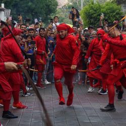 Jóvenes portan atuendos de "Talcigüín" mientras participan en la tradición de "Los Talcigüines" del municipio de Texistepeque, en el departamento de Santa Ana, El Salvador. | Foto:Xinhua/Alexander Peña