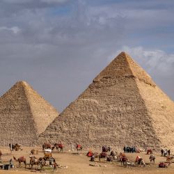 Los guías esperan con sus animales cerca de la Gran Pirámide de Keops y la Pirámide de Kefrén en la necrópolis de las Pirámides de Guiza en las afueras de la capital egipcia. | Foto:AMIR MAKAR / AFP