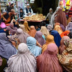 Mujeres vestidas con burka esperan pan gratis en un punto de distribución de Peshawar. - Los paquistaníes pobres se están llevando la peor parte de la crisis económica, y al menos 20 personas han muerto desde el comienzo del mes de ayuno musulmán del Ramadán en aglomeraciones en centros de distribución de alimentos. | Foto:ABDUL MAJEED / AFP