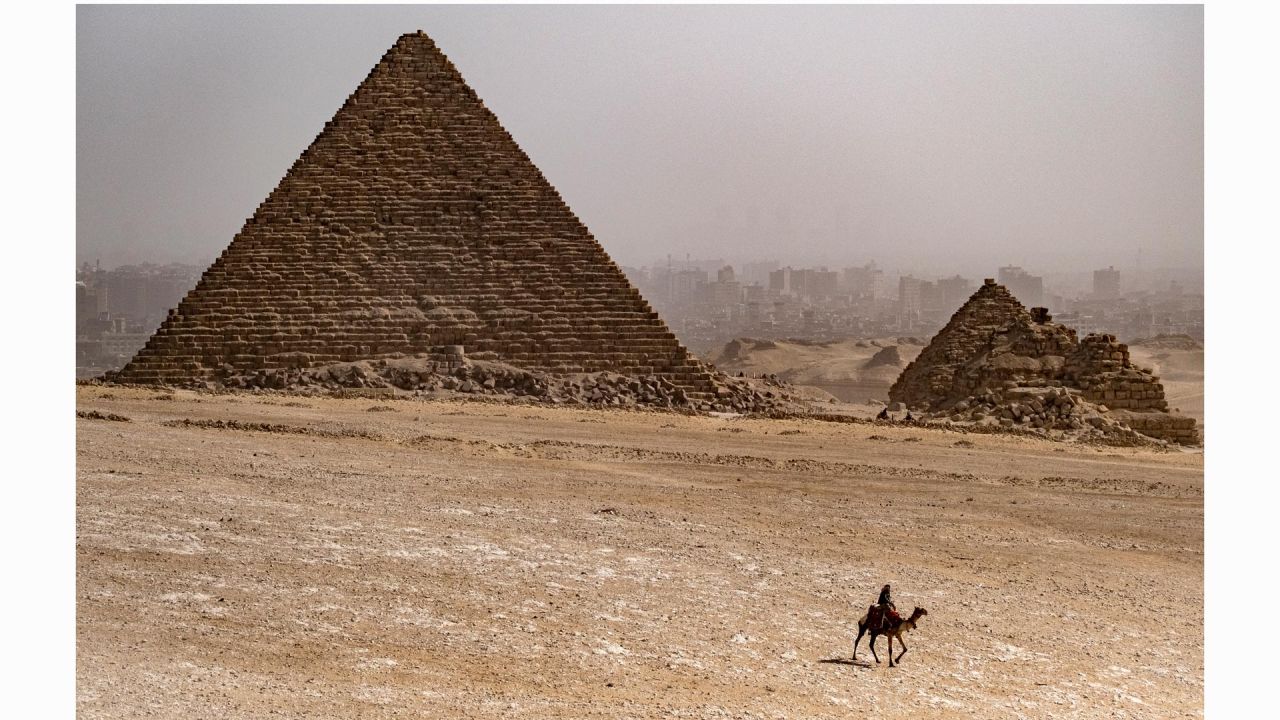 En esta imagen un guía de camellos cabalga cerca de la Pirámide de Menkaure en la necrópolis de las Pirámides de Guiza, a las afueras de la capital egipcia. | Foto:AMIR MAKAR / AFP