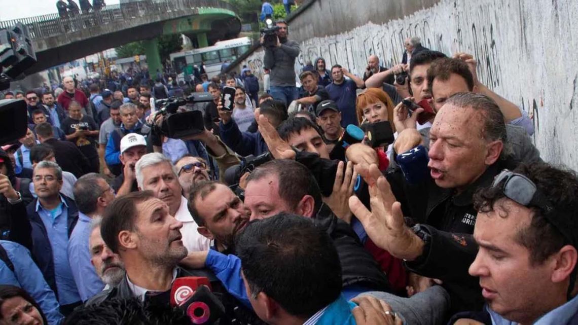 Buenos Aires Province Security Minister Sergio Berni (centre) tries to talk to a crowd of people after being attacked at a protest in La Matanza following the killing of a bus-driver in an armed robbery. 