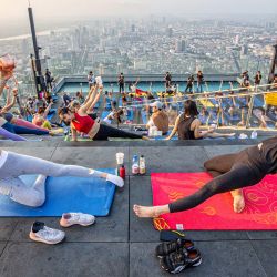 Entusiastas del yoga practican yoga en una plataforma de observación en la azotea del edificio King Power Mahanakhon, en Bangkok, Tailandia. | Foto:Xinhua/Wang Teng