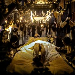 Penitentes preparan una imagen de Cristo antes de participar en la Procesión del Silencio, la procesión más antigua de las Islas Canarias que atraviesa la ciudad completamente a oscuras y en total silencio, en la Ciudad Patrimonio de la Humanidad de San Cristóbal de la Laguna, en la isla canaria de Tenerife. | Foto:DESIREE MARTIN / AFP