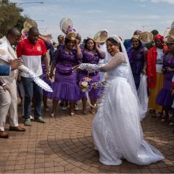 Una novia baila a su llegada a la Iglesia de la Santidad Pentecostal Internacional de Zuurbekom, al sur de Johannesburgo, donde participará en una ceremonia nupcial multitudinaria. | Foto:IHSAAN HAFFEJEE / AFP