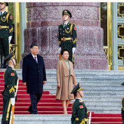 El presidente chino, Xi Jinping y su esposa, Peng Liyuan, bajan los escalones antes de una ceremonia de bienvenida en el Gran Salón del Pueblo de Pekín, en Pekín. | Foto:Ken Ishii / POOL / AFP