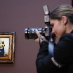 Un fotógrafo toma imágenes junto a la pintura "La lechera" de Johannes Vermeer en el Rijskmuseum de Ámsterdam. | Foto:Ludovic Marin / AFP