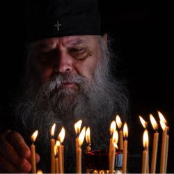 Un sacerdote ortodoxo griego enciende una vela en una iglesia durante la Apokathelosis, que constituye una parte clave de la Pascua ortodoxa, en la Iglesia de la Dormición de la Virgen en Penteli, al norte de Atenas. | Foto:Angelos Tzortzinis / AFP