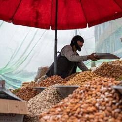 Un vendedor afgano vende frutos secos en un mercado en Kabul. | Foto:WAKIL KOHSAR / AFP