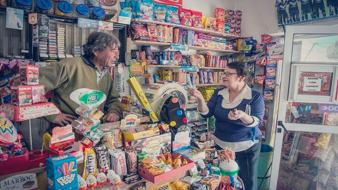 A kiosquero chats to a customer at his store.