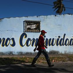 Un hombre pasa junto a una pintada en la que se lee "Somos Continuidad" junto a una imagen de una bandera cubana en una calle de La Habana, Cuba | Foto:YAMIL LAGE / AFP