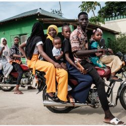 Fieles musulmanes toman una mototaxi para ir a la playa con motivo de la celebración del Eid al-Fitr, que marca el final del mes sagrado de ayuno del Ramadán, en Malindi, Kenia. | Foto:YASUYOSHI CHIBA / AFP