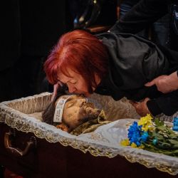 Tetiana besa a su hijo fallecido Valerii Dorokhov tendido en un ataúd, durante su ceremonia fúnebre en el monasterio ortodoxo de San Miguel de Cúpula Dorada en Kiev, en medio de la invasión rusa de Ucrania. | Foto:DIMITAR DILKOFF / AFP