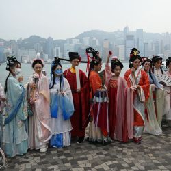 Un grupo de personas posa con trajes tradicionales chinos en Hong Kong. | Foto:PETER PARKS / AFP