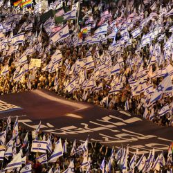Manifestantes levantan banderas y pancartas durante una concentración para protestar contra el proyecto de ley de reforma judicial del gobierno israelí en Tel Aviv. | Foto:JACK GUEZ / AFP