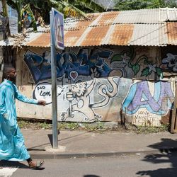Un hombre camina por las calles de Kaweni, Mamoudzou, en la isla de Mayotte. - Se esperaba que las autoridades de Mayotte pusieran en marcha la operación Wuambushu ("Retomar") este mismo fin de semana para expulsar a los inmigrantes ilegales que se han asentado en los barrios marginales de la isla, con más de 2.000 policías y funcionarios administrativos movilizados para poner en marcha las expulsiones de los que se encuentran ilegalmente en la isla y derribar las ocupaciones ilegales improvisadas que los albergan. | Foto:Patrick Meinhardt / AFP