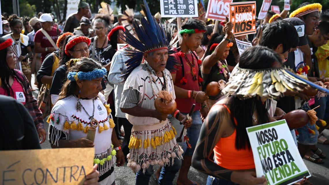 Indigenous people taking part in the Terra Livre Indigenous camp, focused on bringing awareness for indigenous rights and land issues and promoting their culture, protest outside the Congress building in Brasilia on April 24, 2023. 