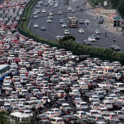 En esta foto se ven vehículos durante un atasco en la autopista Delhi-Jaipur en Gurgaon. - Cada mañana y cada tarde -y durante varias horas entre una y otra- decenas de millones de indios permanecen inactivos en autopistas atascadas y cuelgan de los laterales de trenes de pasajeros abarrotados en lo que se está convirtiendo en la nación más poblada del mundo. | Foto:Vinay Gupta / AFP