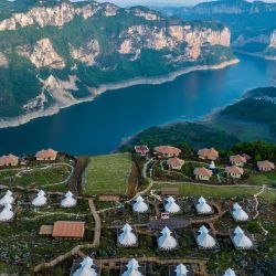Esta foto aérea muestra casas construidas cerca de un acantilado en un camping en Bijie, en la provincia suroccidental china de Guizhou. | Foto:AFP