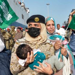 Un marinero de la Marina saudí lleva a un niño mientras los evacuados llegan a la base naval Rey Faisal en Yeda, tras una operación de rescate desde Sudán. - Un barco con 1.687 civiles de más de 50 países que huían de la violencia en Sudán atracó en Arabia Saudí, según informó el Ministerio de Asuntos Exteriores, lo que supone la mayor operación de evacuación llevada a cabo por el reino del Golfo hasta la fecha. | Foto:AMER HILABI / AFP