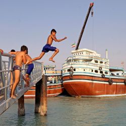 Jóvenes nadan a lo largo de la costa de la isla iraní de Qeshm, en el Golfo. | Foto:ATTA KENARE / AFP